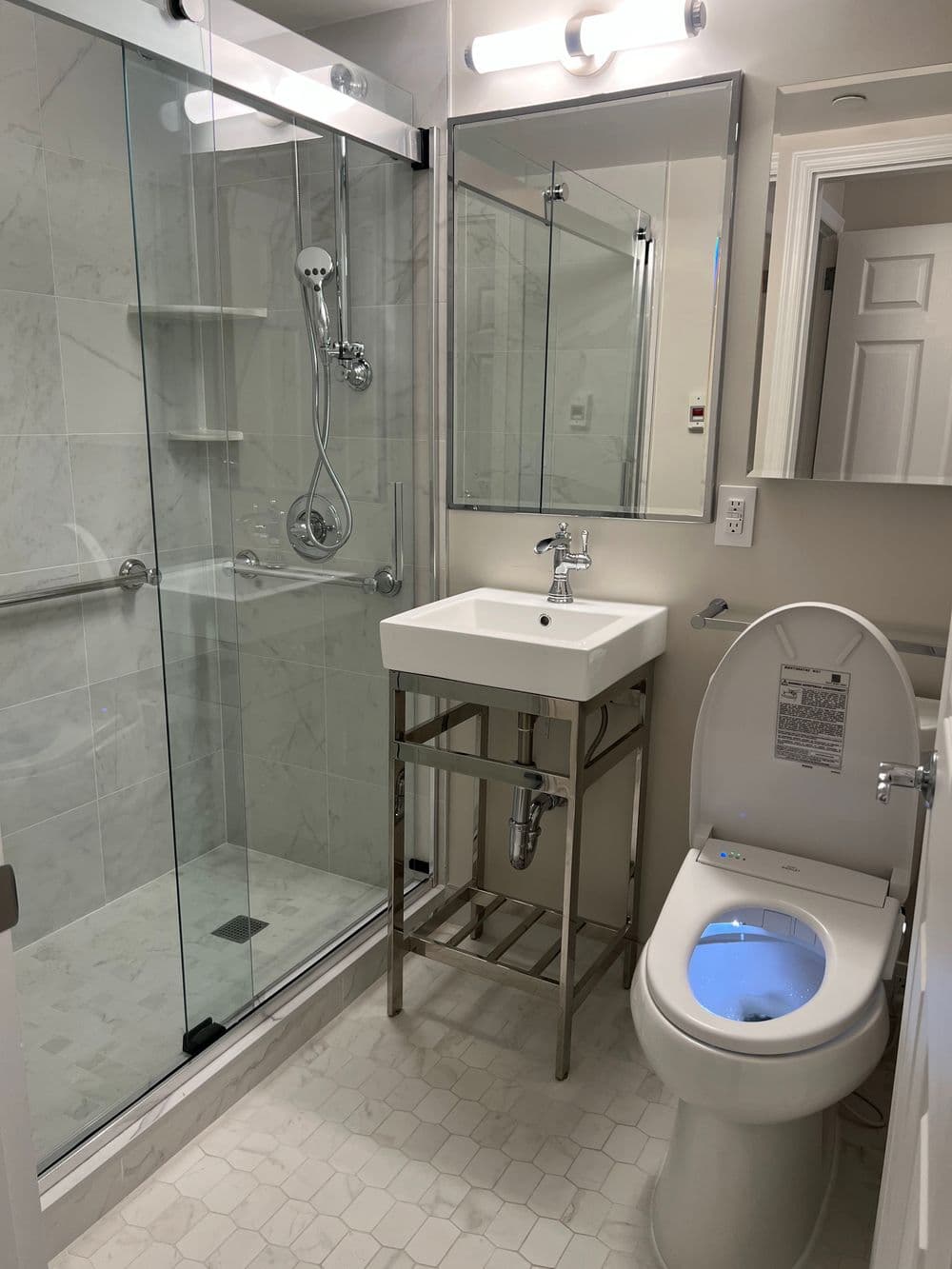 Modern bathroom featuring a glass shower, stylish sink, and advanced toilet design.
