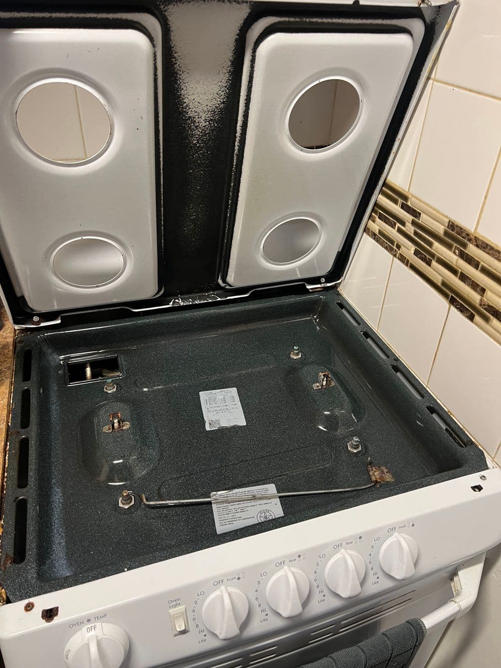 Open gas stove with two burners, control knobs, and a clean, well-maintained interior.